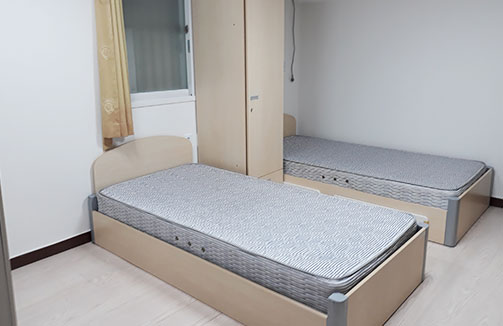 싱글침대 두개와 침대가운데 길다란 옷장이 놓여 있다.