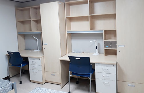 똑같이 생긴 책상과 의자가 2개 나란히 놓여 있다.