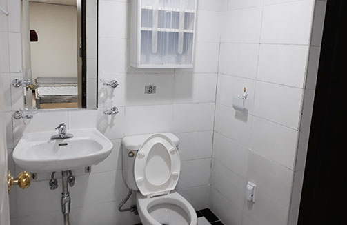 화장실에는 거울, 세면대, 변기가있다.