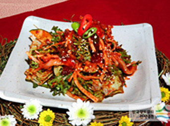 붉은빛 양념이 각종채소와 버무려져 흰접시위에 담긴 서대회무침