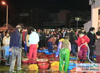 사람들이 수협위판장에서 경매를 하고 있는 모습