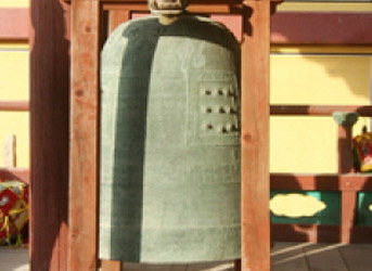 커다란 동종이 나무 지지대에 매달려있는 모습