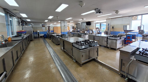 싱크대가 나열되어 있고 중앙에 가스레인지가 있다