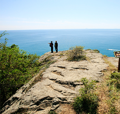 바다가 내려다 보이는 바위에서있는 사람들