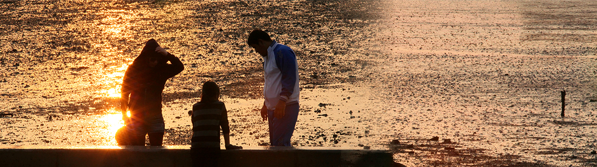 갯벌에서 노을을 감상하는 가족 모습