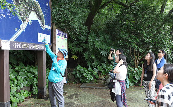 오동도관광안내도를 보면서 설명하는 해설가와 이를 듣고있는 관광객들