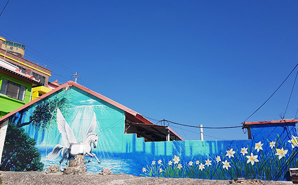 날개달린 백마가 꽃밭을 향해 날아가는 그림이 벽에 그려져 있다.