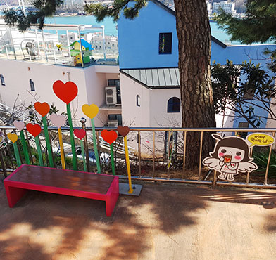 빨간 벤치와 하트모양 조형물이 있는 포토존