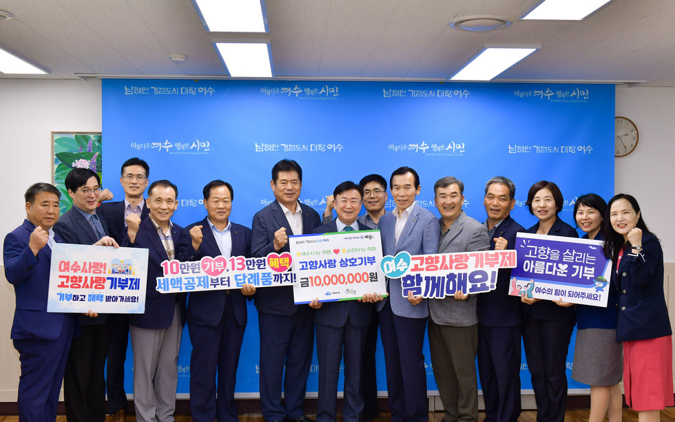 여수시청에서 고향사랑 기부제를 홍보하는 행사에 참석한 여러 사람들이 기부를 독려하는 현수막을 들고 포즈를 취하고 있다.