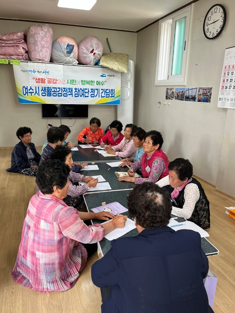 여수시에서 생활공감정책 참여단 정기 간담회가 열리고 있으며, 여러 명의 노인이 테이블에 앉아 회의 중이다.