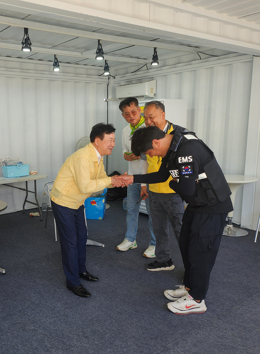 여수시장과 관계자들이 축제 현장 상황실에서 안전 요원을 격려하며 악수하는 장면