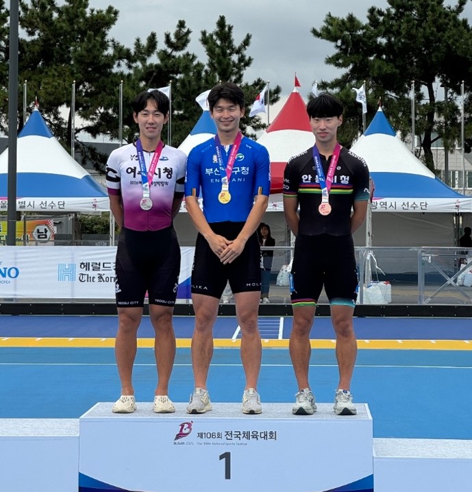 여수시청 선수들이 제106회 전국체육대회에서 메달을 수상하며 기념사진을 찍고 있다. 중앙에는 금메달을 목에 건 선수가 있다.