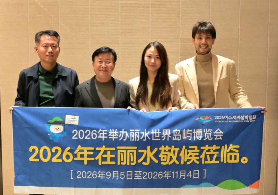 정기명 여수시장과 중국 유명 인플루언서 마이클 부부가 함께 ‘2026여수세계섬박람회’ 홍보 현수막을 들고 기념 촬영하는 모습