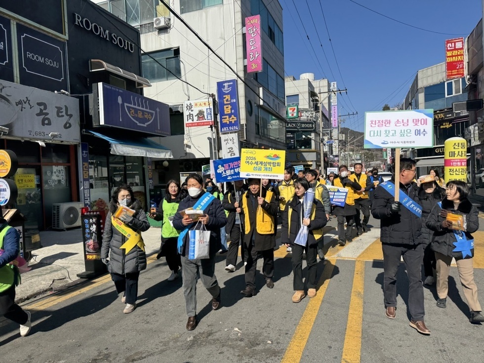 여수에서 2026 여수세계섬박람회 성공을 기원하며 시민들이 행진하고 있다. 참가자들은 다양한 현수막과 팻말을 들고 거리에서 캠페인을 진행하고 있다.