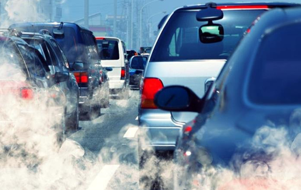 차량들이 도로에서 정체되어 있으며, 배기가스가 뿜어져 나오는 모습이다.