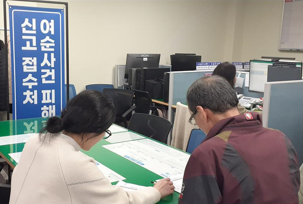 여순사건 피해 접수처에서 두 사람이 서류를 작성하고 있는 모습이다.