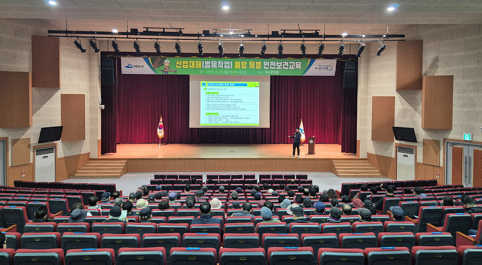 여수문화홀에서 산업재해 예방을 위한 특별 안전보건교육이 진행되고 있으며, 강사가 발표를 하고 있다. 청중이 강의를 듣고 있다.