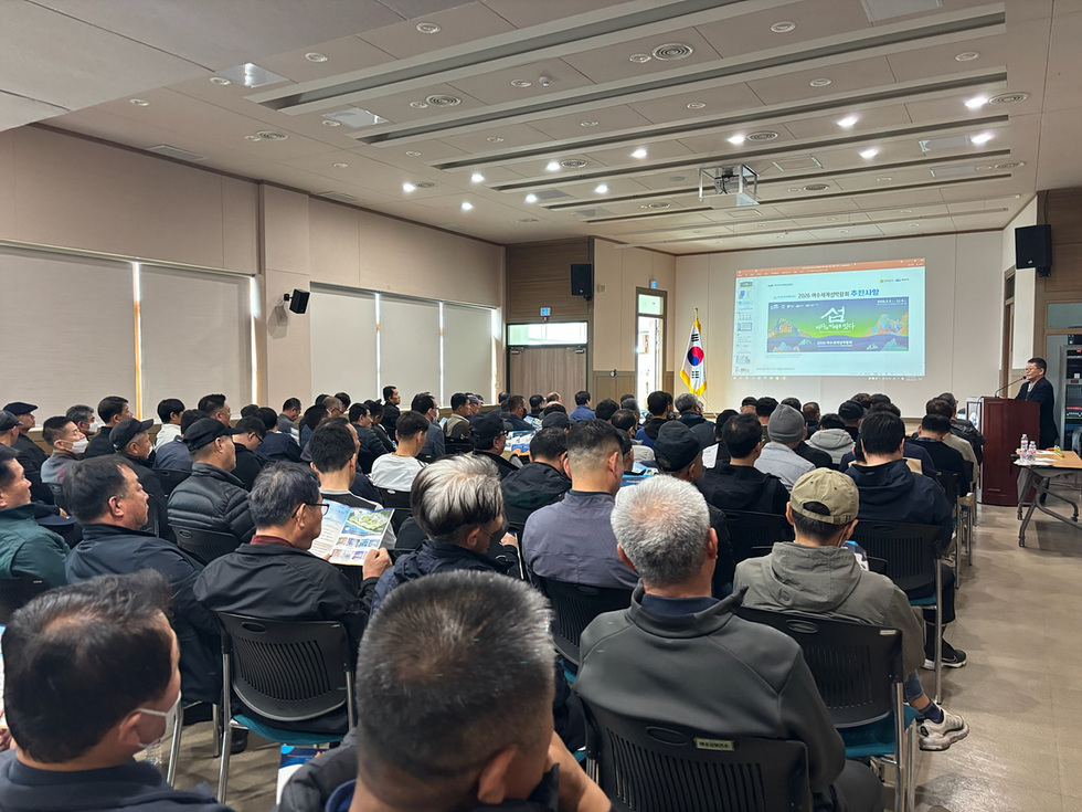 어업인대회에 참석한 많은 사람들이 발표를 듣고 있는 모습으로, 화면에는 대회 안내가 표시되어 있다.