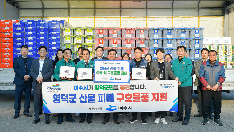 여수시 관계자들이 영덕군 산불 피해를 돕기 위해 구호물품을 전달하는 행사에서 기념사진을 찍고 있다.