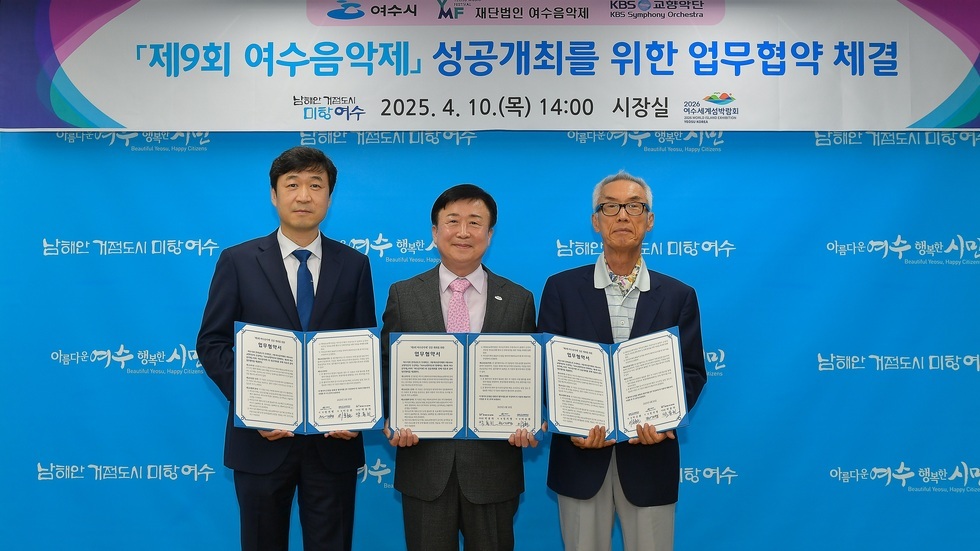 여수시에서 제9회 여수음악제 성공 개최를 위한 업무협약을 체결하는 장면으로, 세 명의 남성이 협약서를 들고 서 있다.