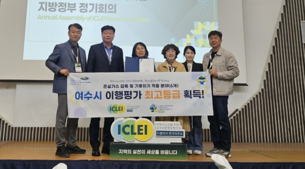 여수시 관계자를 비롯한 수상자들이 단상에 서서 인증서를 펼쳐 보이고 있는 장면