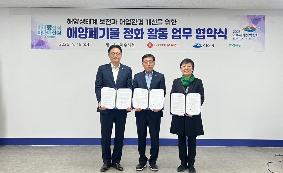 여수시청에서 해양생태계 보전과 어업환경 개선을 위한 해양폐기물 정화 활동 업무 협약식이 진행되고 있다. 세 명의 참석자가 협약서를 들고 서 있다.