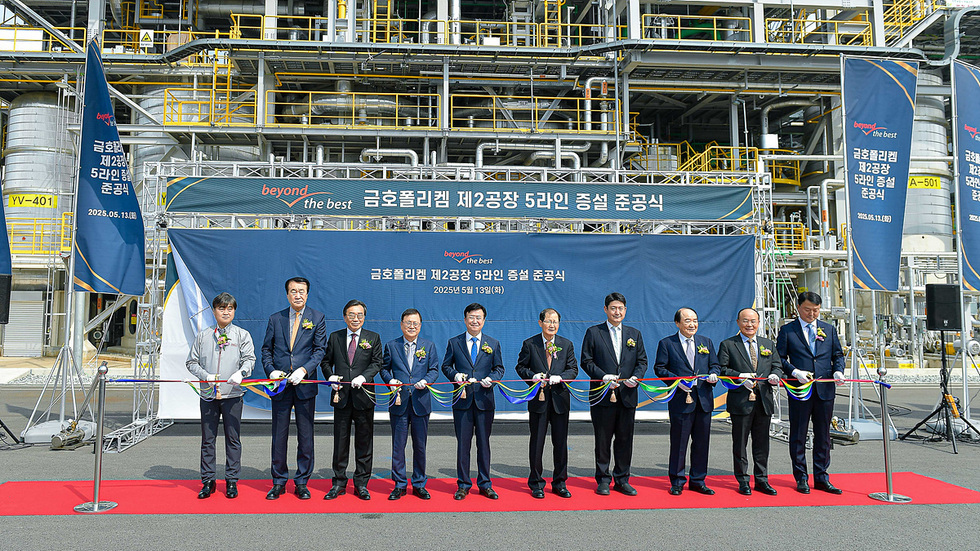 금호폴리켐 제2공장 5라인 증설 준공식에서 여러 인사가 리본을 자르고 있다. 배경에는 공장 시설이 보인다.