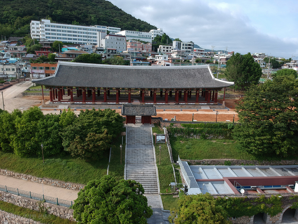 전통 건축물인 사찰이 보이는 풍경으로, 주변에는 현대적인 건물과 나무들이 있다. 사찰 앞에는 계단이 있으며, 배경에는 주택가가 자리잡고 있다.