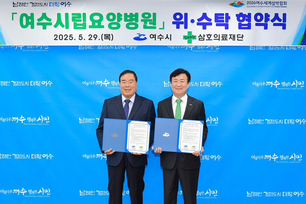 여수시립요양병원과 삼호의료재단 간의 위수탁 협약식에서 두 남성이 협약서를 들고 서 있다.