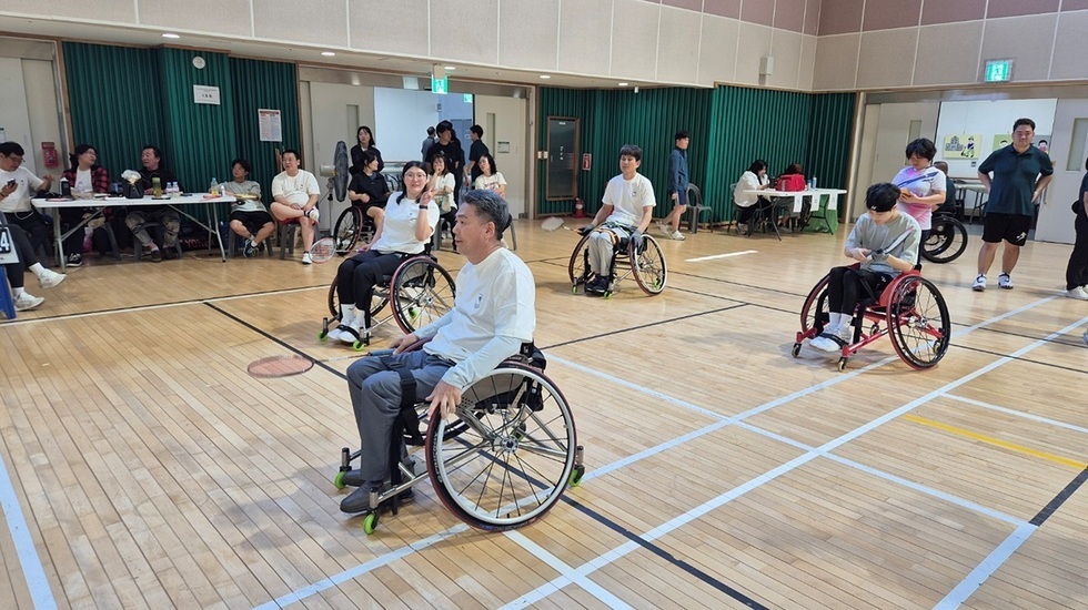 여수시장애인국민체육센터에서 열린 휠체어 배드민턴 경기, 선수들이 휠체어에 앉아 경기에 집중하는 모습