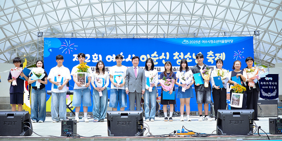 여수시청소년미래재단에서 제2회 여수시 이순신 청소년 축제가 열리고 있으며, 여러 청소년들이 상장과 꽃다발을 들고 기념사진을 찍고 있다.