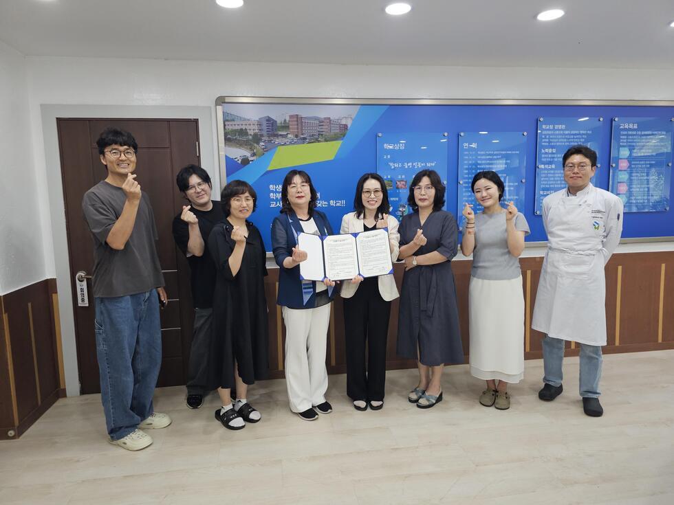 여섯 명의 사람들이 협약서를 들고 포즈를 취하고 있는 모습으로, 배경에는 학교 관련 정보가 담긴 패널이 있다.