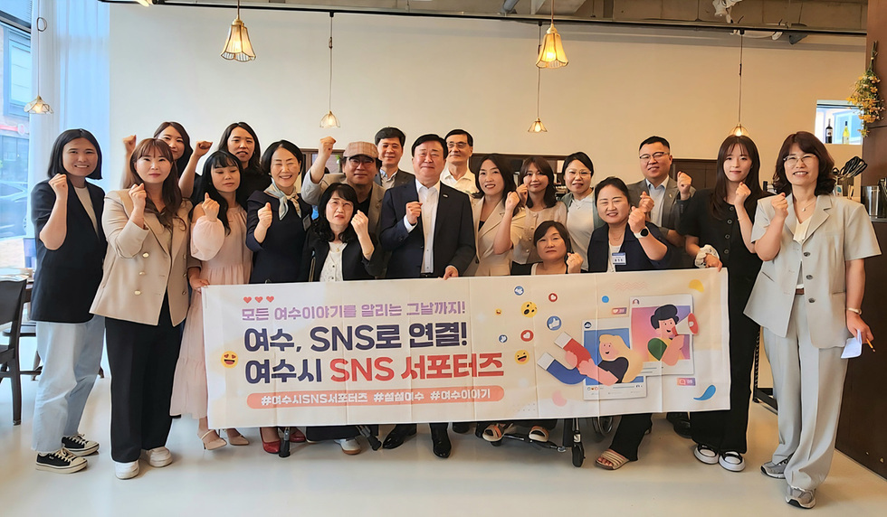 여수시 SNS 서포터즈 발대식에서 참석자들이 기념사진을 찍고 있다. 현수막에는 여수와 SNS를 연결하자는 내용이 적혀 있다.