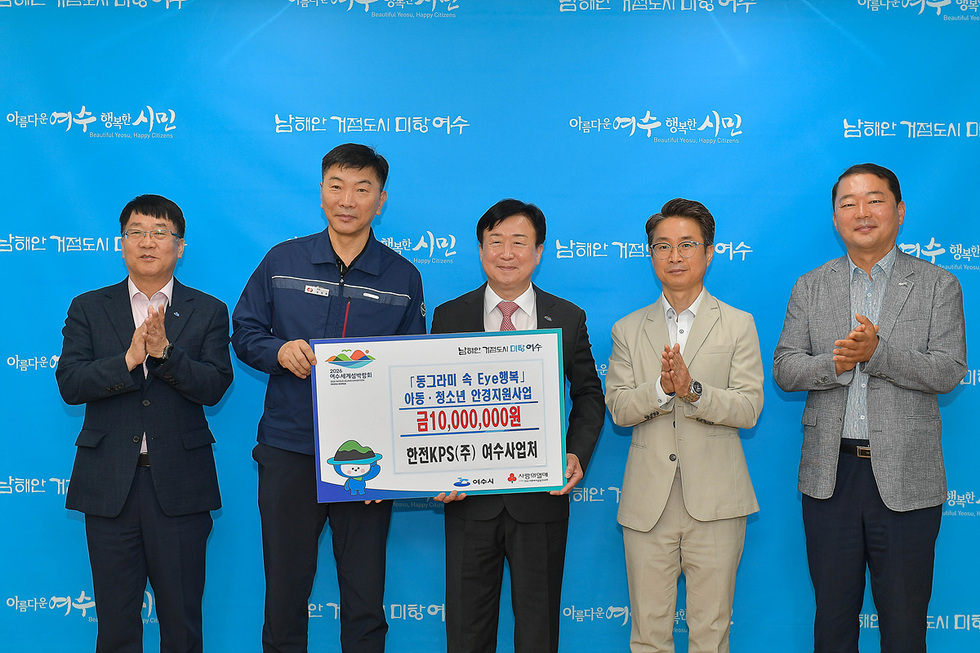 동그라미 속 Eye행복 아동·청소년 안전지원사업 금10,000,000원 한전KPS(주) 여수사업처 후원에 관한 판낼을 들고 찍은 사진