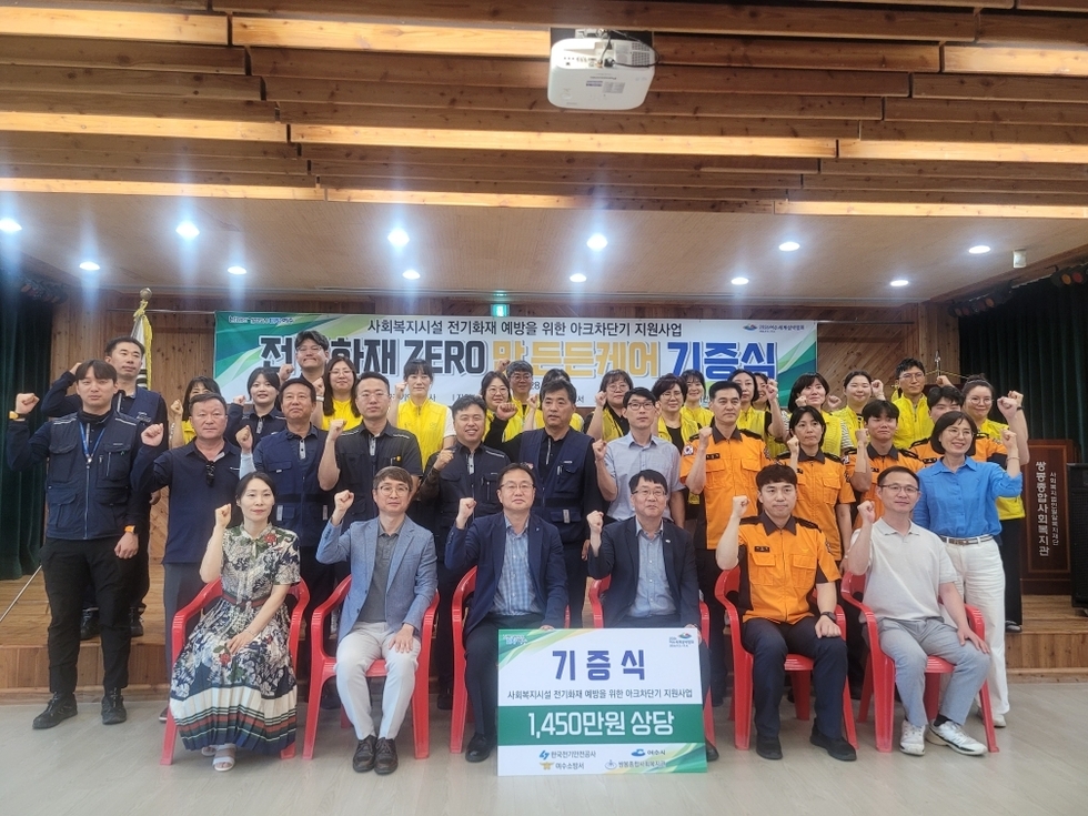 여수시와 한국전기안전공사, 여수소방서, 쌍봉종합사회복지관 관계자들이 아크차단기 기증식에서 단체 기념촬영을 하며 화이팅 포즈를 취하는 모습