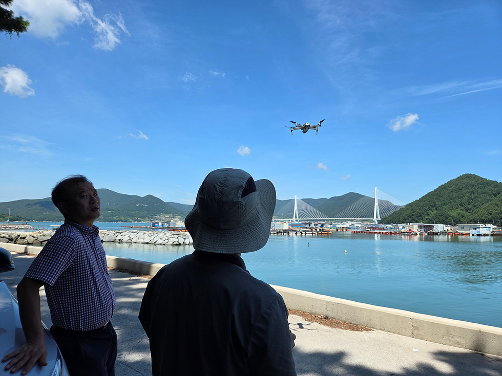 여수시 관계자가 바닷가에서 드론을 띄워 해상 상황을 점검하는 모습