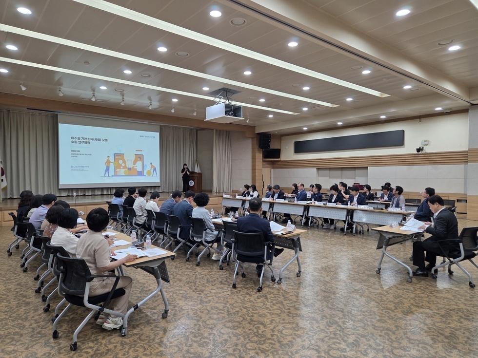 회의실에서 발표자가 기획스케치에 대해 설명하고 있으며, 참석자들이 주의 깊게 듣고 있는 장면이다.