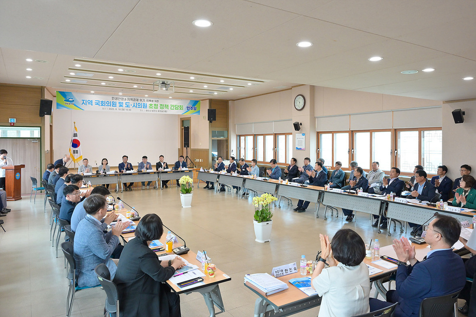 지역 국회의원과 도시의원들이 모여 정책 간담회를 진행하는 모습으로, 참석자들이 앉아 있고 일부는 박수를 치고 있다.