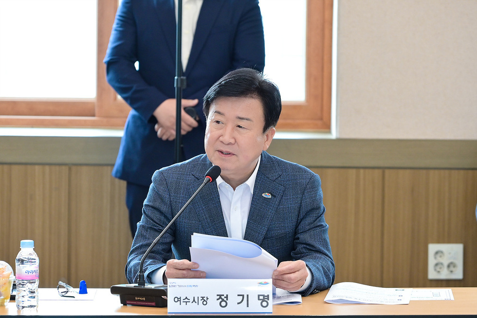 여수시장에서 정기명이 회의 중 발언하고 있는 모습이다. 테이블 위에는 문서와 물병이 놓여 있다.