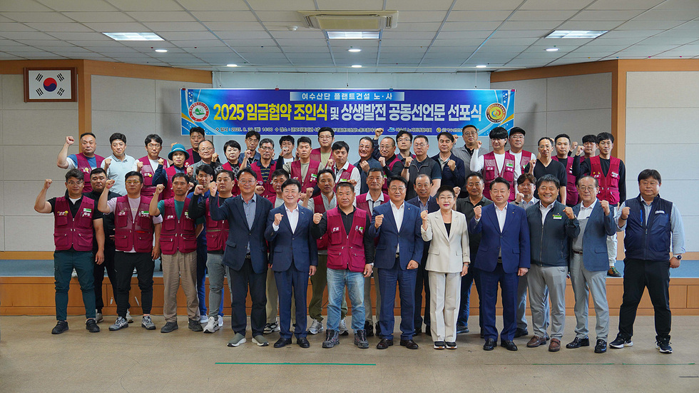 여수시청에서 2025 임금협약 조인식 및 상생발전 공동선언문 선포식이 진행되고 있으며, 참석자들이 단체 사진을 찍고 있다.