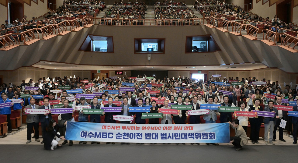 여수MBC의 순천 이전에 반대하는 시민들이 모여 현수막을 들고 있는 모습으로, 많은 사람들이 참석한 행사로 보인다.