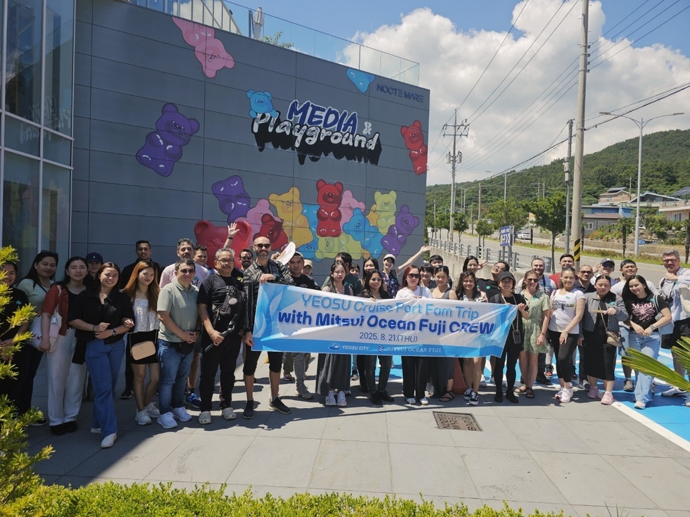여수 크루즈 포트 패밀리 트립에 참여한 Mitsui Ocean Fuji 크루가 함께 사진을 찍고 있는 장면으로, 배경에는 미디어 놀이터의 벽화가 보인다.