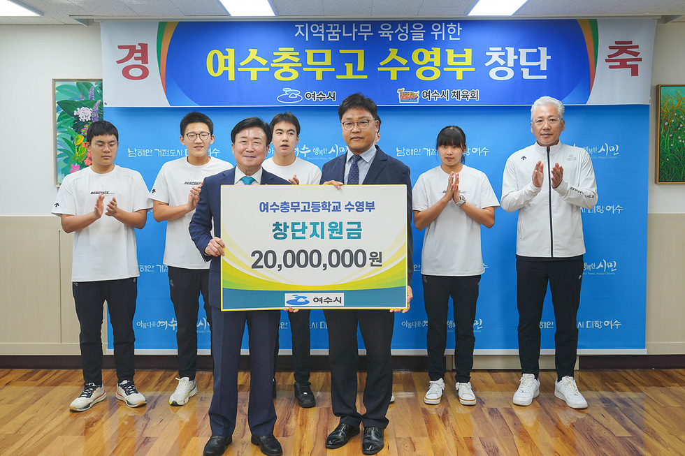 여수총무고등학교 수영부 창단을 축하하는 행사에서 관계자들이 지원금 증서를 들고 기념사진을 찍고 있다.