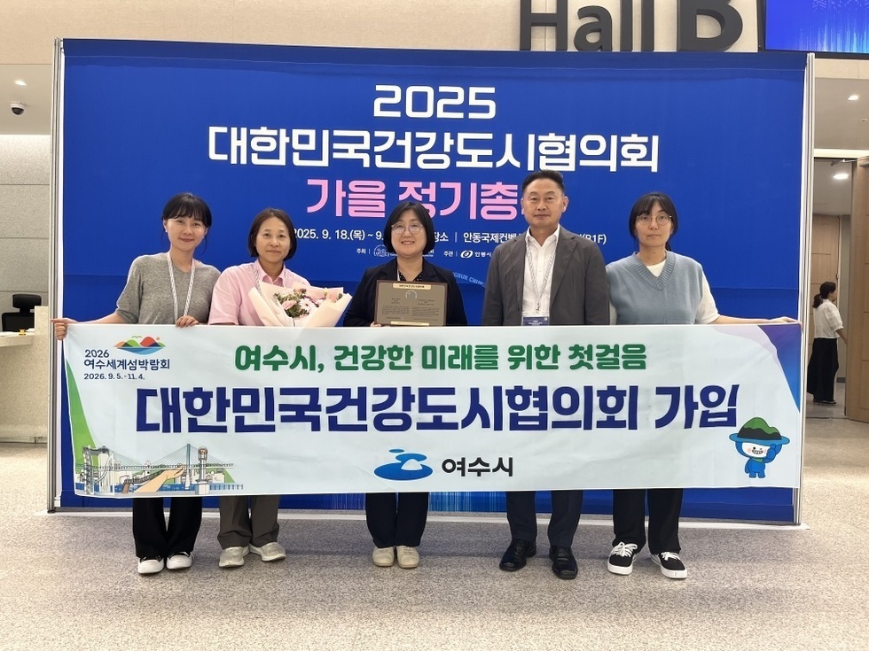 여수시 관계자들이 대한민국건강도시협의회 가입 현수막을 들고 기념사진을 찍고 있는 모습