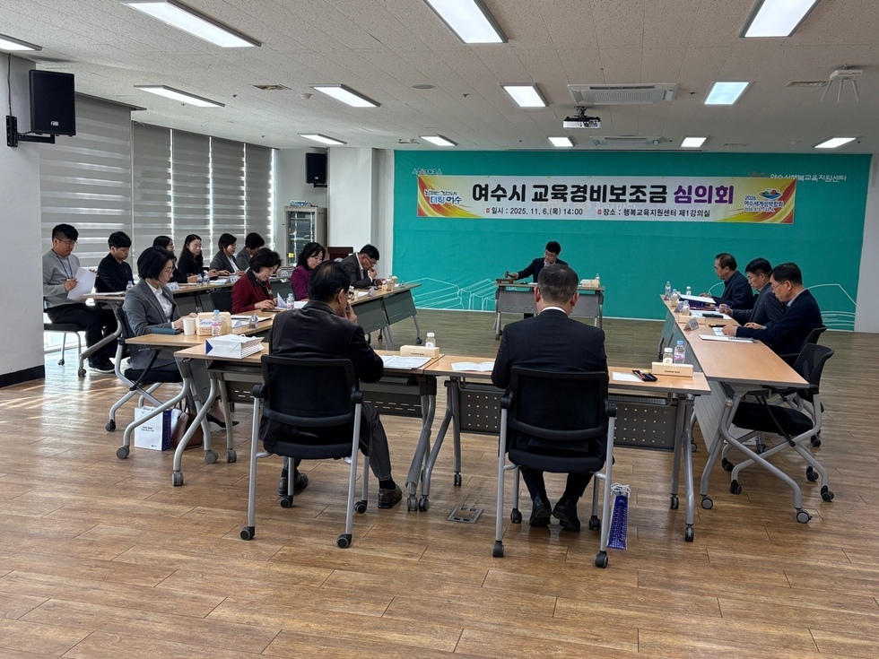 ‘여수시 교육경비보조금 심의회’ 현수막이 걸린 회의실에서 관계자들이 회의 테이블에 앉아 2026년 교육경비 보조사업 지원 계획을 논의하고 있는 모습