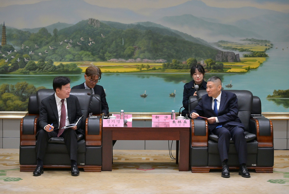 여수시 정기명 시장이 중국 리수이시를 방문해 주린썬 시장과 마주 앉아 대화를 나누는 모습. 배경에는 평화로운 산수화풍의 회화가 걸려 있다.