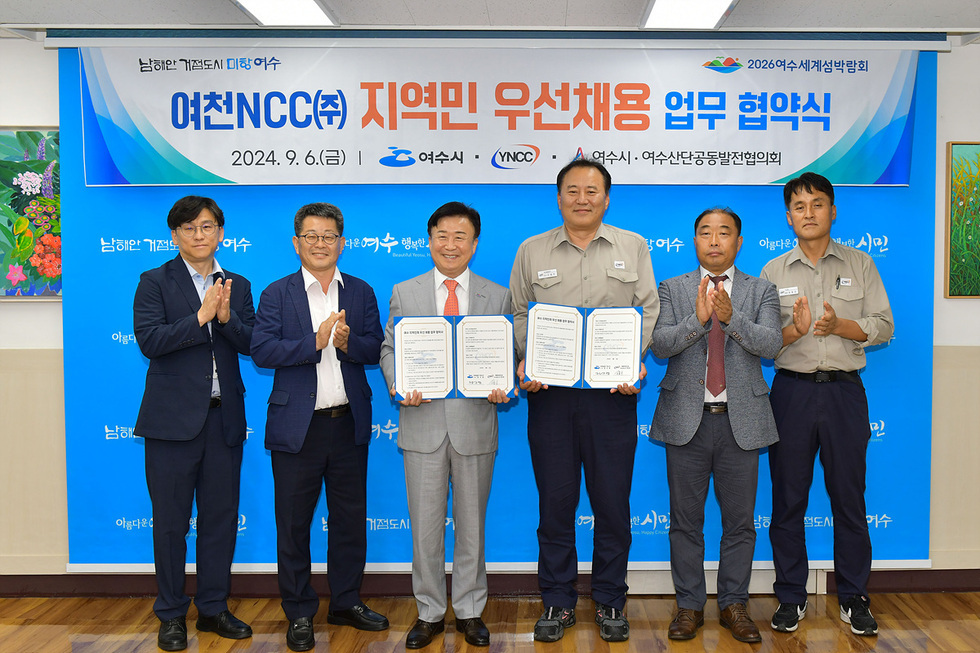 여천NCC와 여수시 간의 지역민 우선채용 업무 협약식이 진행되고 있으며, 참석자들이 협약서를 들고 기념사진을 찍고 있다.