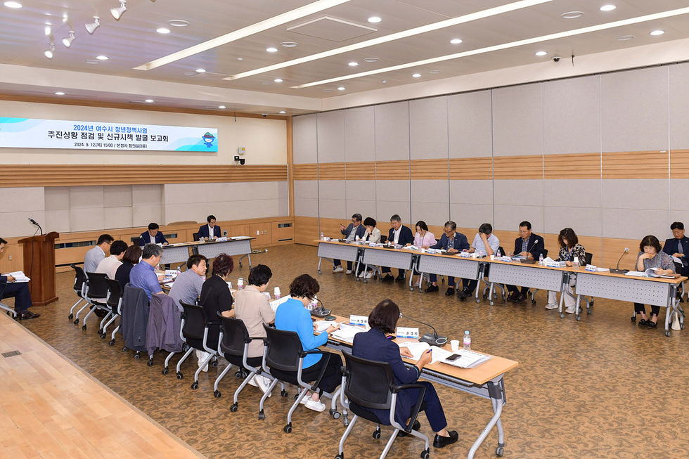회의실에서 여러 사람들이 모여 청년정책사업에 대한 점검 및 발표를 하고 있는 장면이다.