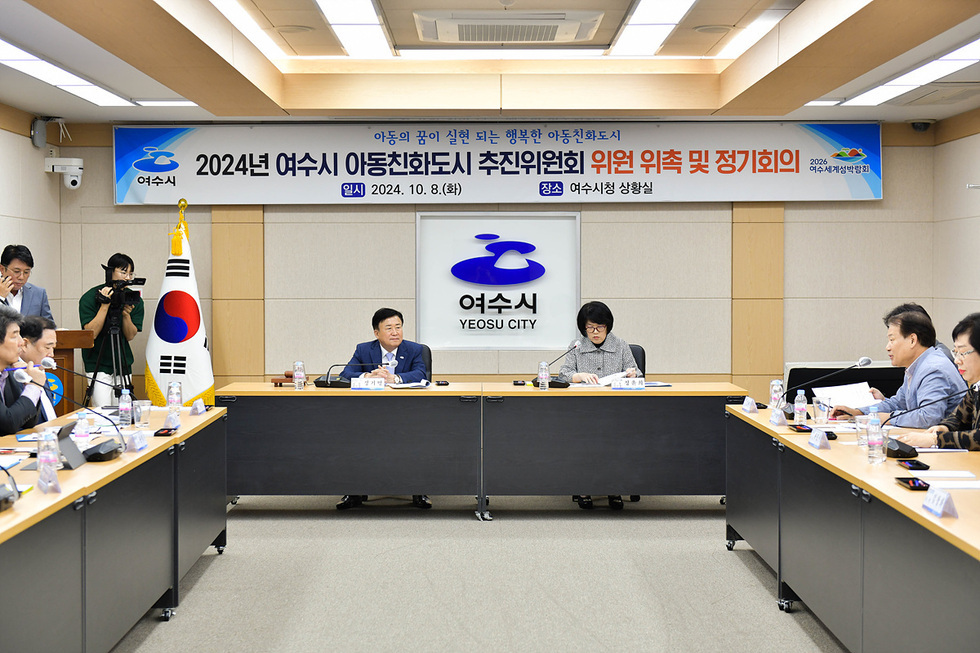 여수시청 상황실에서 2024년 아동친화도시 추진위원회 위원 위촉 및 정기회의가 진행되고 있다. 회의 중인 위원들과 여수시청 로고가 보인다.