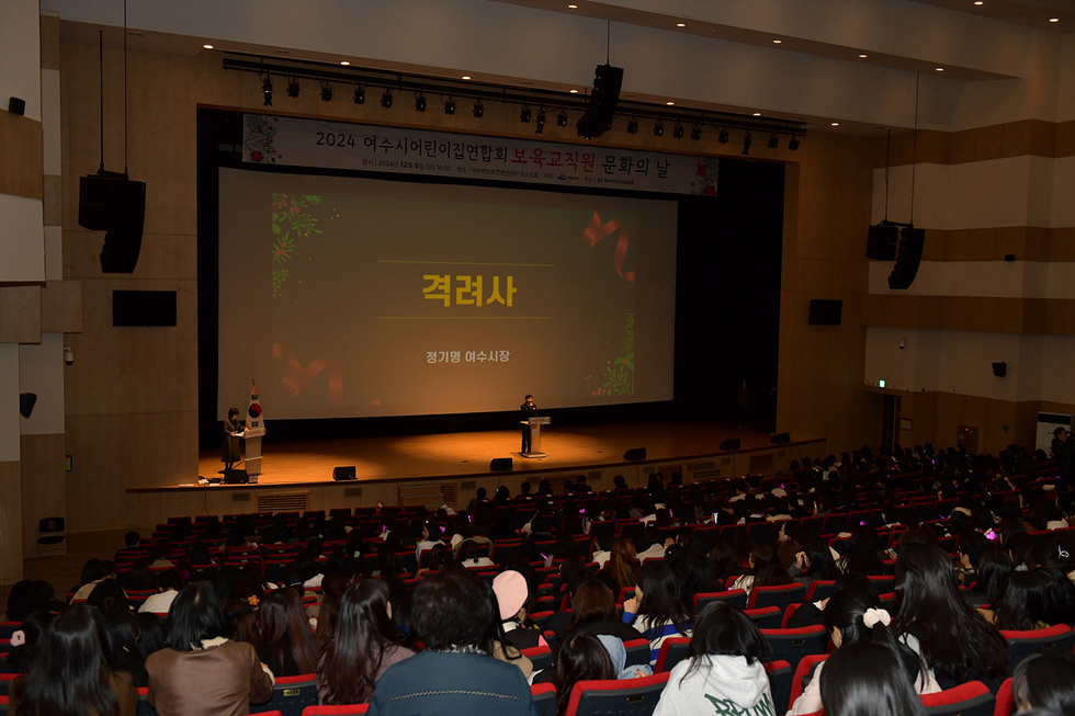 여수시어린이집연합회 보육교직원 문화의 날 행사에서 정기명 여수시장이 격려사를 하고 있으며, 관객들이 강연을 듣고 있는 모습이다.
